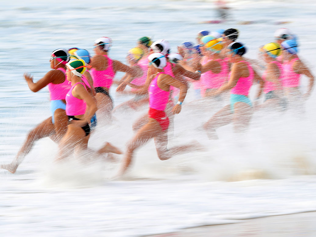Swim competitors running into the water