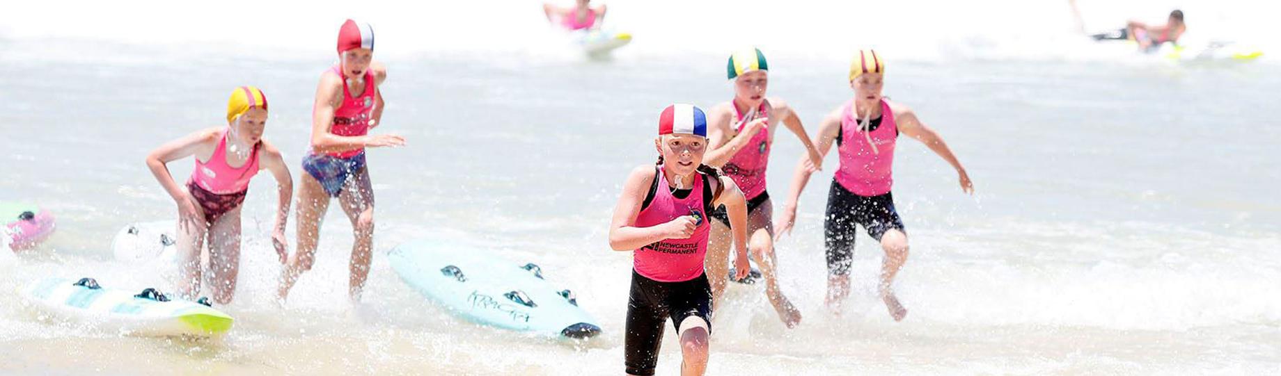 Young athletes running out of the surf
